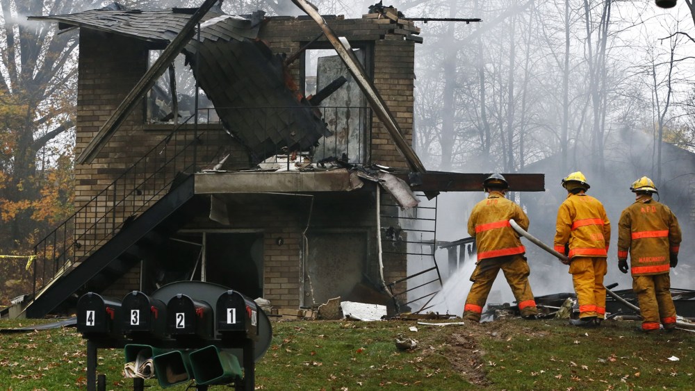 Firefighters work at the scene where authorities say a small business jet crashed into an apartment building in Akron, Ohio, Tuesday, Nov. 10, 2015. (Photo by Ed Suba Jr./Akron Beacon Journal/AP)