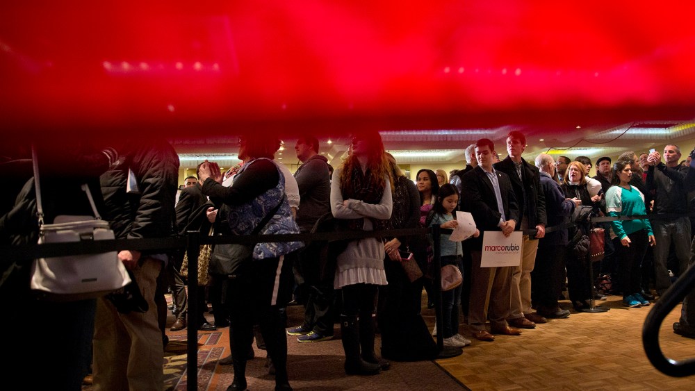 Seen from behind a American flag, supporters of Sen. Marco Rubio, R-Fla. gather for his primary night rally at the Radisson Hotel in Manchester, N.H., Feb. 9, 2016. (Photo by Jacquelyn Martin/AP)