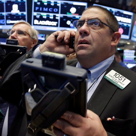 Trader Robert Oswald, right, works on the floor of the New York Stock Exchange, Aug. 26, 2015. (Photo by Richard Drew/AP)