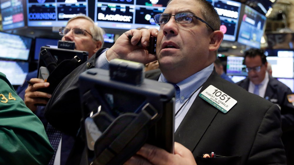 Trader Robert Oswald, right, works on the floor of the New York Stock Exchange, Aug. 26, 2015. (Photo by Richard Drew/AP)