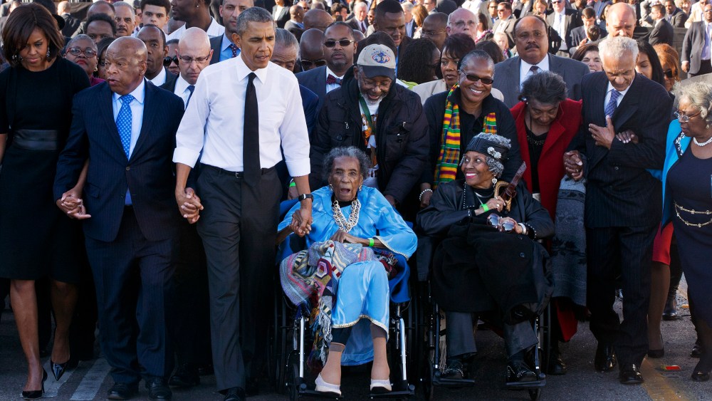 Amelia Boynton Robinson, center, who was beaten during "Bloody Sunday," holds President Barack Obama's hand as they walk across the Edmund Pettus Bridge in Selma, Ala., Saturday, March 7, 2015. (Photo by Jacquelyn Martin/AP)