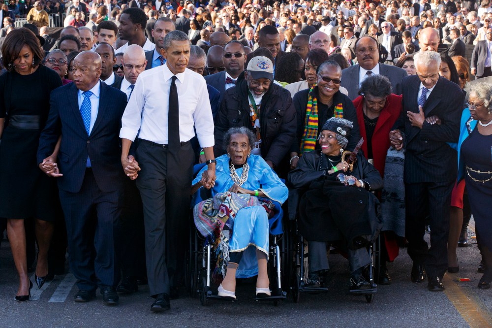 Amelia Boynton Robinson, center, who was beaten during "Bloody Sunday," holds President Barack Obama's hand as they walk across the Edmund Pettus Bridge in Selma, Ala., Saturday, March 7, 2015. (Photo by Jacquelyn Martin/AP)