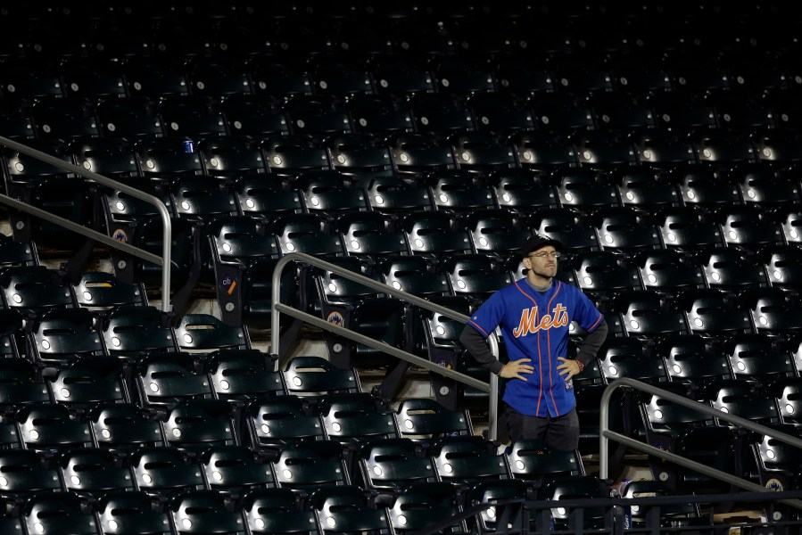 A New York Mets fan watches as the Kansas City Royals celebrates after Game 5 of the Major League Baseball World Series, Nov. 2, 2015, in New York. (Photo by Julie Jacobson/AP)