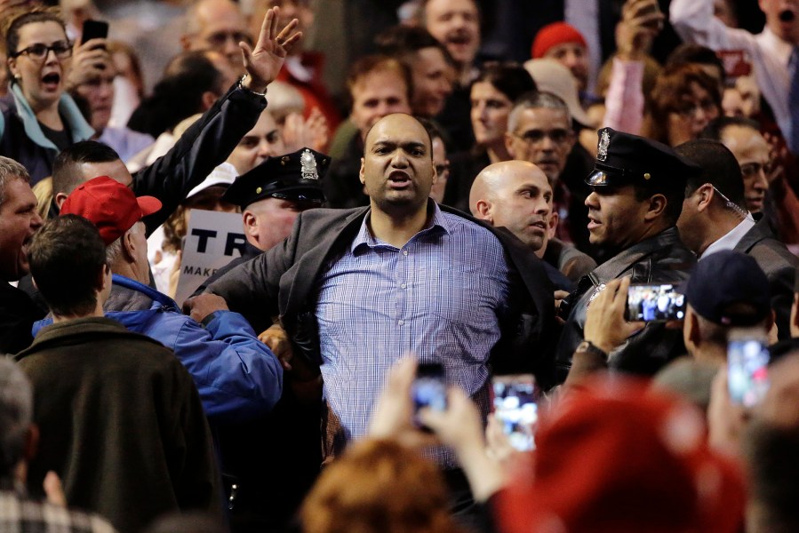 Members of law enforcement escort a man from a campaign event for Republican presidential candidate, businessman Donald Trump, Nov. 18, 2015, in Worcester, Mass. (Photo by Steven Senne/AP)