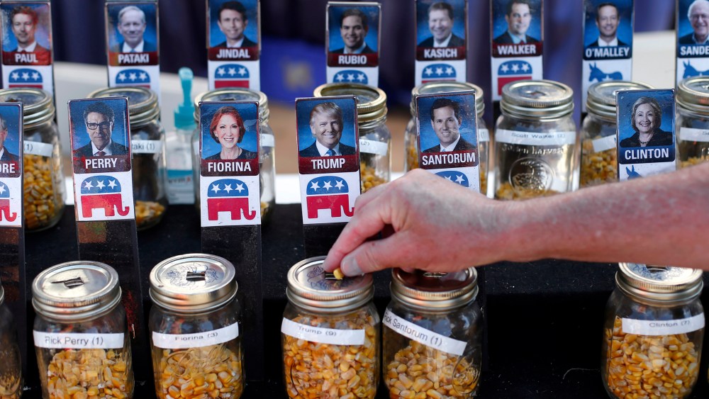 A visitor casts their vote with a kernel of corn for presidential candidate Donald Trump in a straw poll at the Iowa State Fair, Aug. 20, 2015, in Des Moines, Iowa. (Photo by Paul Sancya/AP)