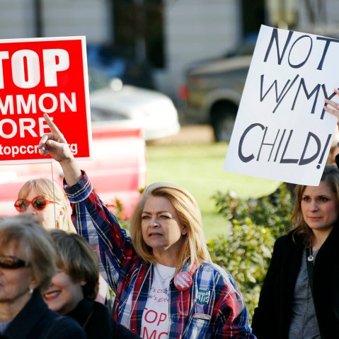 Common Core opponents wave signs and cheer at a rally opposing Mississippi's continued use of the Common Core academic standards on the steps of the Capitol in Jackson, Miss., Jan. 6, 2015. (Photo by Rogelio V. Solis/AP)