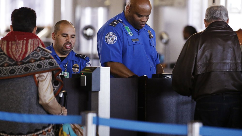 In this Nov. 25, 2015 file photo, TSA agents check travelers' identifications at O'Hare International Airport in Chicago. (Photo by Nam Y. Huh/AP)