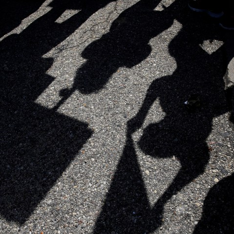 Demonstrators casts shadows as they gather outside the Holiday Inn Express in Janesville, Wis. on March 29, 2016. (Photo by Nam Y. Huh/AP)