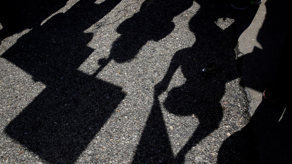 Demonstrators casts shadows as they gather outside the Holiday Inn Express in Janesville, Wis. on March 29, 2016. (Photo by Nam Y. Huh/AP)