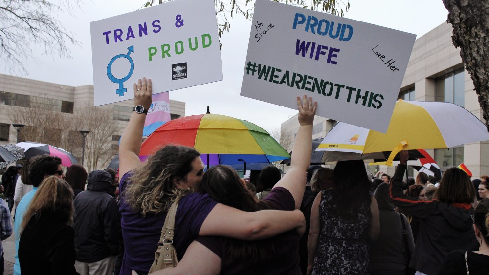 Two protesters hold up signs against passage of legislation in North Carolina, which limits the bathroom options for transgender people, during a rally in Charlotte, N.C., March 31, 2016. (Photo by Skip Foreman/AP)