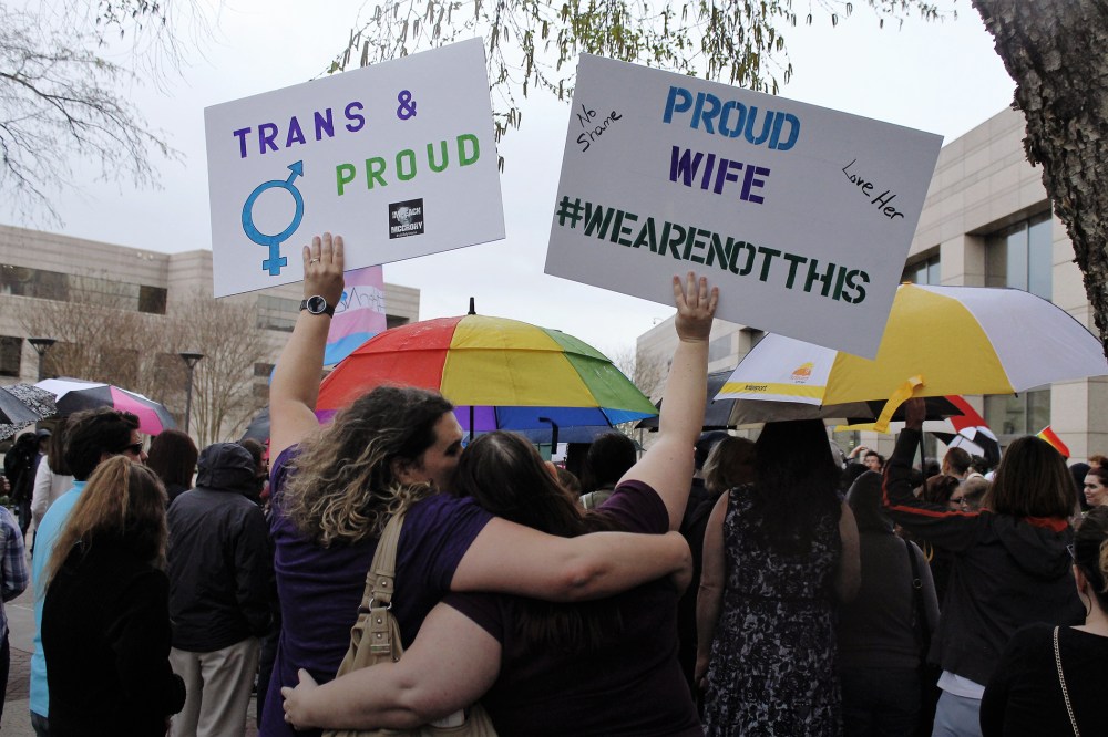 Two protesters hold up signs against passage of legislation in North Carolina, which limits the bathroom options for transgender people, during a rally in Charlotte, N.C., March 31, 2016. (Photo by Skip Foreman/AP)