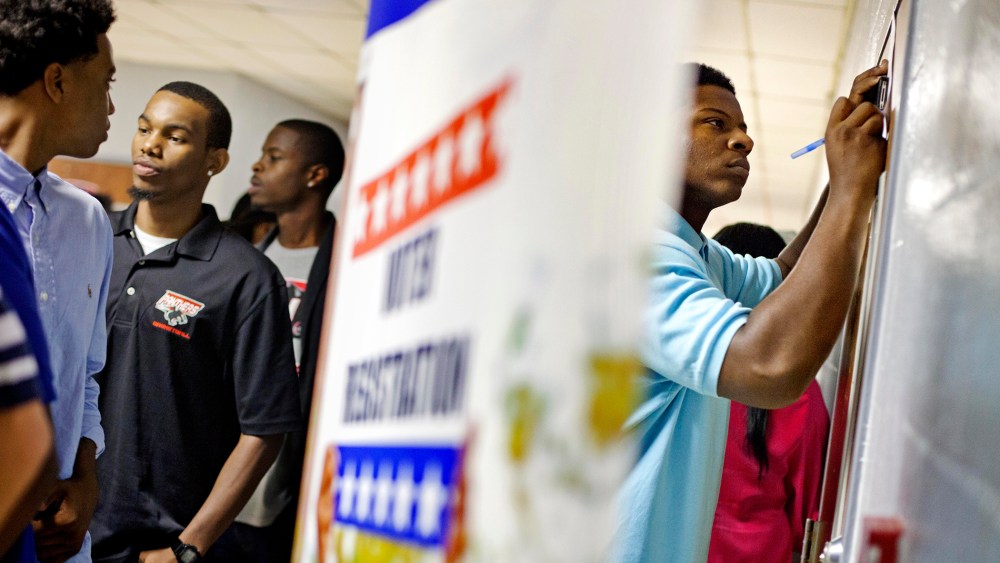 Students at Clark Atlanta University fill out voter registration forms, Sept. 18, 2012, in Atlanta, Ga. (Photo by David Goldman/AP)
