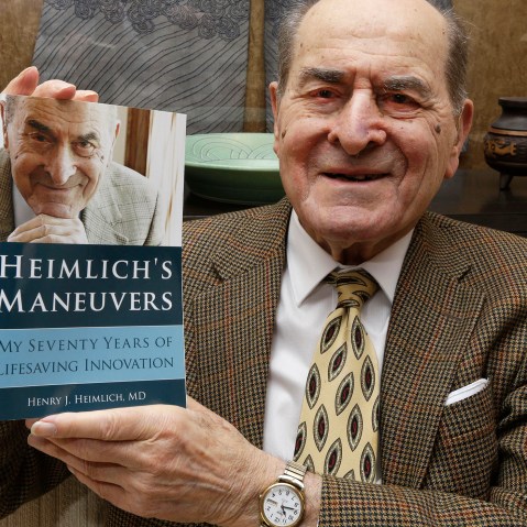 In this Wednesday, Feb. 5, 2014 photo, Dr. Henry Heimlich holds his memoirs prior to being interviewed at his home in Cincinnati. (Photo by Al Behrman/AP)