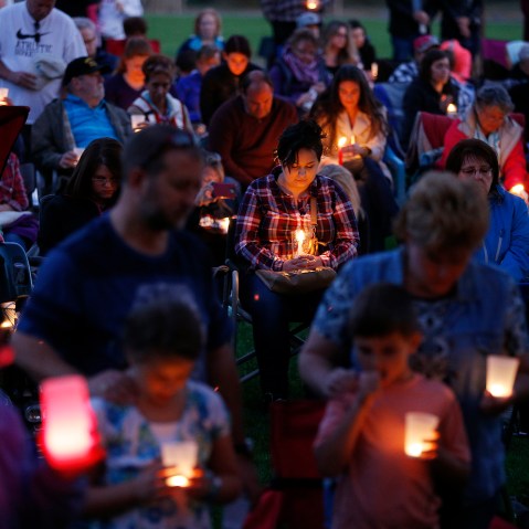 People bow their heads in prayer during a vigil held in honor of the victims of the fatal shooting at Umpqua Community College, Oct. 3, 2015, in Winston, Ore. (Photo by John Locher/AP)