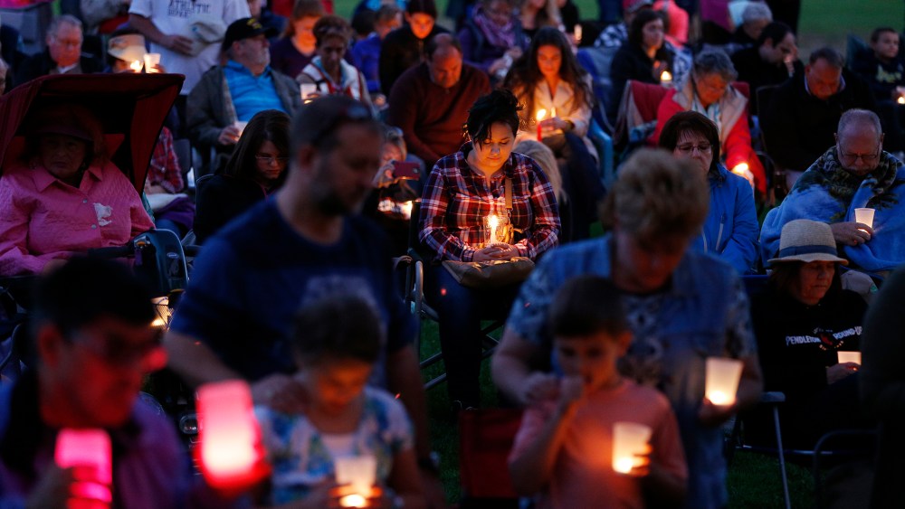 People bow their heads in prayer during a vigil held in honor of the victims of the fatal shooting at Umpqua Community College, Oct. 3, 2015, in Winston, Ore. (Photo by John Locher/AP)