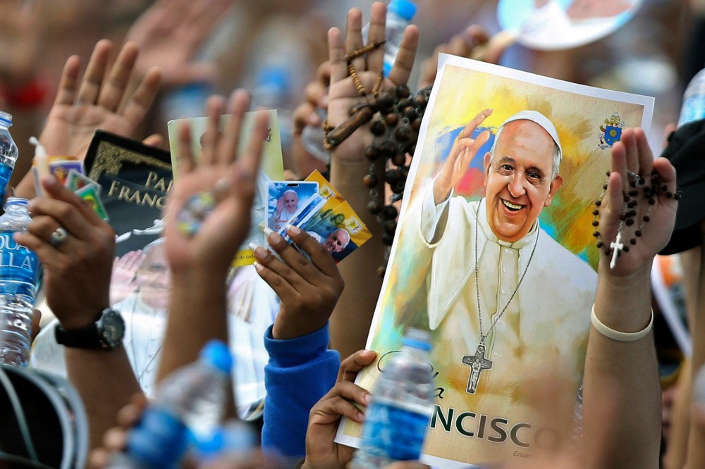 Pilgrims hold up their hands to be blessed by Pope Francis during a Mass at the Samanes Park in Guayaquil, Ecuador on July 6, 2015. (Photo by Fernando Vergara/AP)