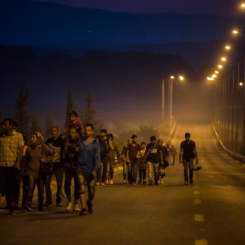 Syrian refugees walk along the roads of the border town of Idomeni, northern Greece to cross the border and enter Macedonia, on Aug. 25, 2015. (Photo by Santi Palacios/AP)
