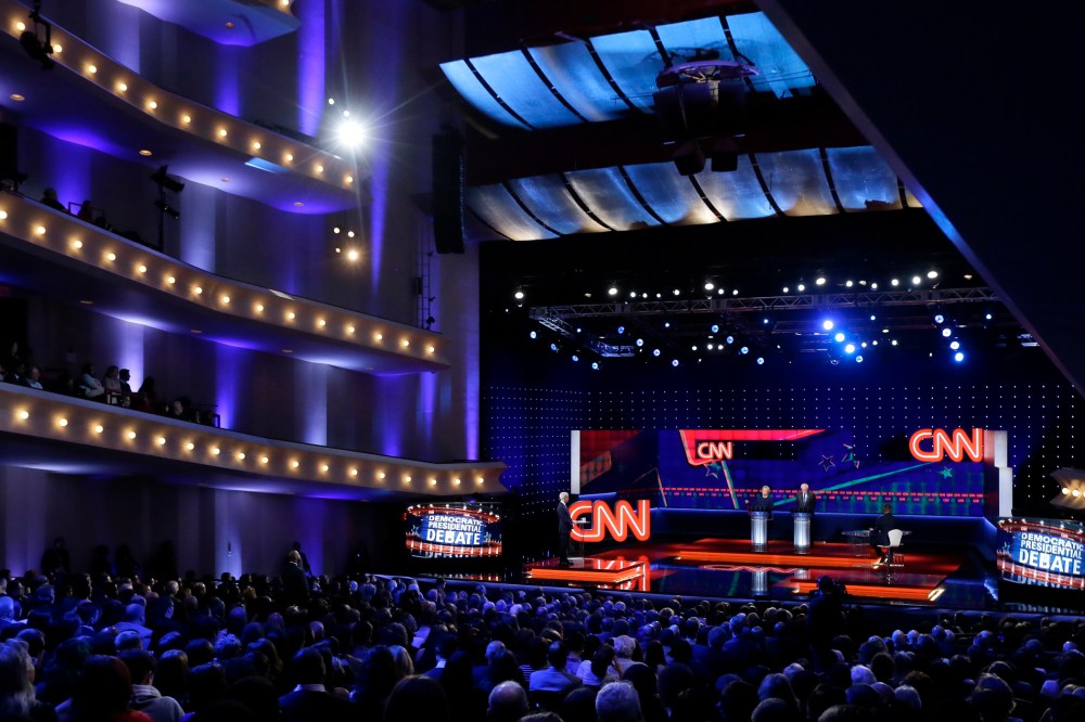 Democratic presidential candidates Hillary Clinton, left, and, Sen. Bernie Sanders listen to a question during a Democratic presidential primary debate at the University of Michigan-Flint on March 6, 2016, in Flint, Mich. (Photo by Carlos Osorio/AP)