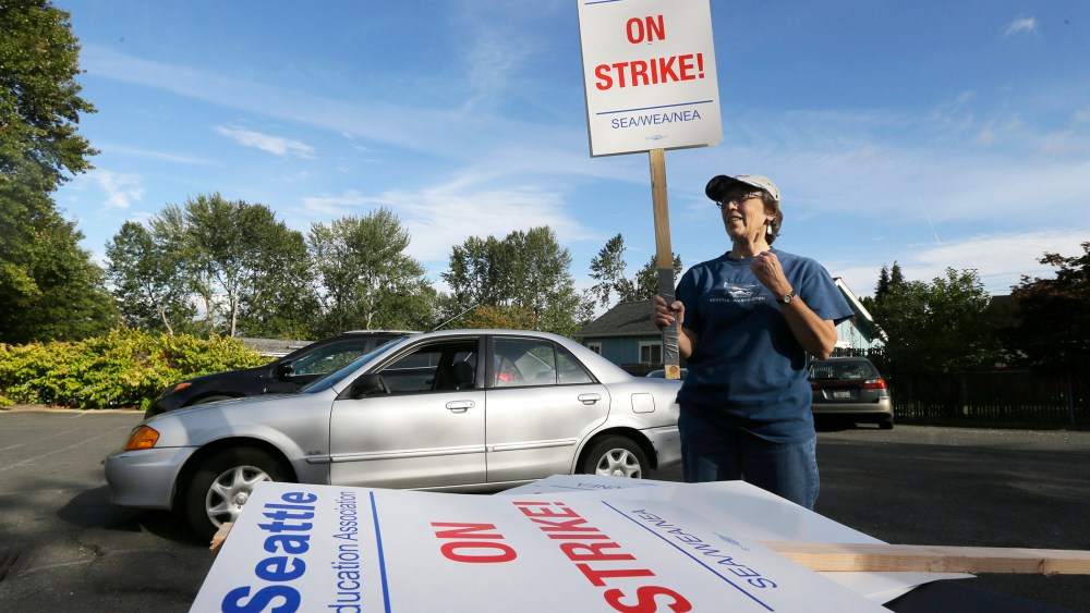 Nancy Kiser, a fifth-grade teacher at Kimball Elementary School, examines a picket sign to be used in the event of a strike by teachers in the Seattle School District on Sept. 8, 2015, in Seattle, Wash. (Photo by Ted S. Warren/AP)
