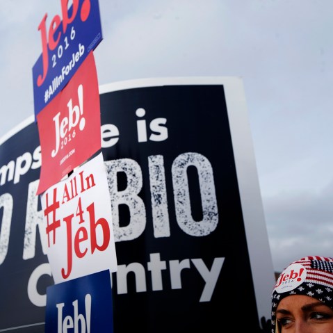 A voter holds a sign outside a polling site at Bedford High School, Feb. 9, 2016, in Bedford, N.H. (Photo by John Minchillo/AP)