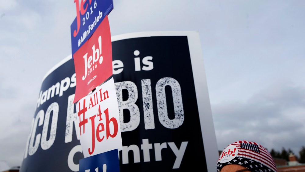 A voter holds a sign outside a polling site at Bedford High School, Feb. 9, 2016, in Bedford, N.H. (Photo by John Minchillo/AP)
