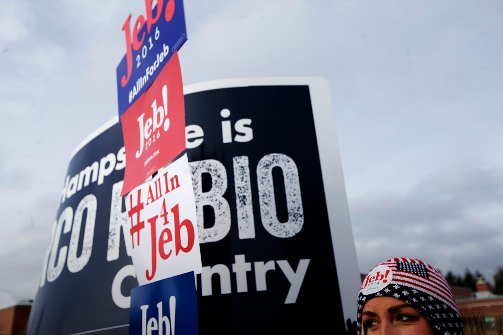 A voter holds a sign outside a polling site at Bedford High School, Feb. 9, 2016, in Bedford, N.H. (Photo by John Minchillo/AP)