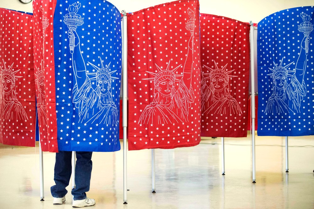 A voter marks a ballot for the New Hampshire primary inside a voting booth at a polling place, Feb. 9, 2016, in Manchester, N.H. (Photo by David Goldman/AP)