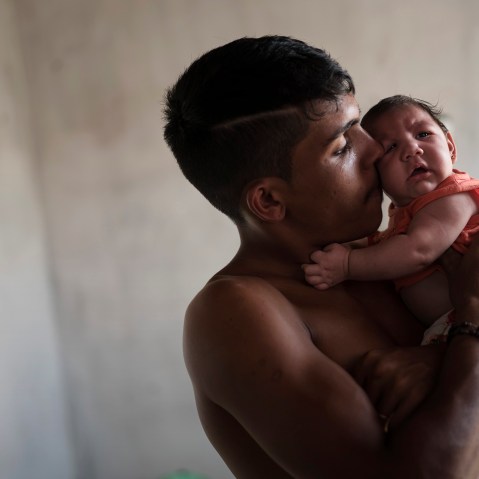 In this Dec. 23, 2015 photo, Dejailson Arruda holds his daughter Luiza at their house in Santa Cruz do Capibaribe, Pernambuco state, Brazil. (Photo by Felipe Dana/AP)