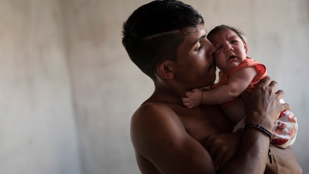 In this Dec. 23, 2015 photo, Dejailson Arruda holds his daughter Luiza at their house in Santa Cruz do Capibaribe, Pernambuco state, Brazil. (Photo by Felipe Dana/AP)