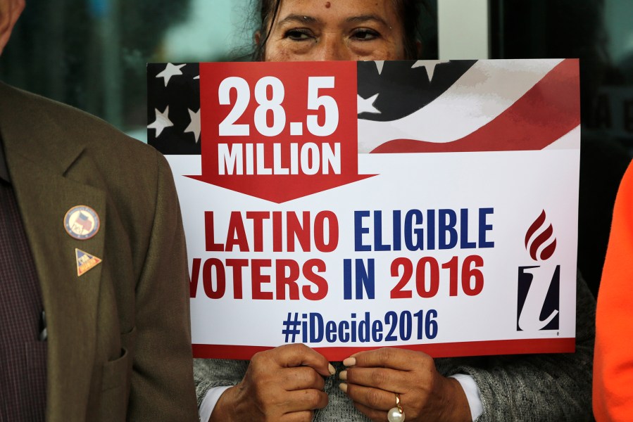 Georgina Arcienegas holds a sign in support of Latino voters during a protest outside the office of Florida Rep. Carlos Trujillo, Jan. 12, 2016, in Doral, Fla. (Photo by Lynne Sladky/AP)