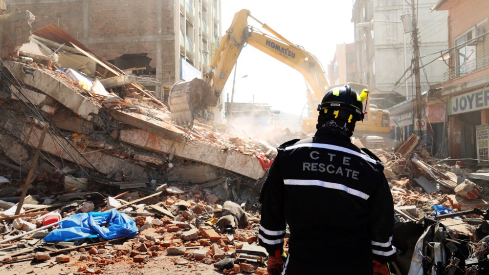 A rescue worker looks as heavy machinery removes the debris of a collapsed building in Portoviejo, Ecuador, April 17, 2016. (Photo by Carlos Sacoto/AP)