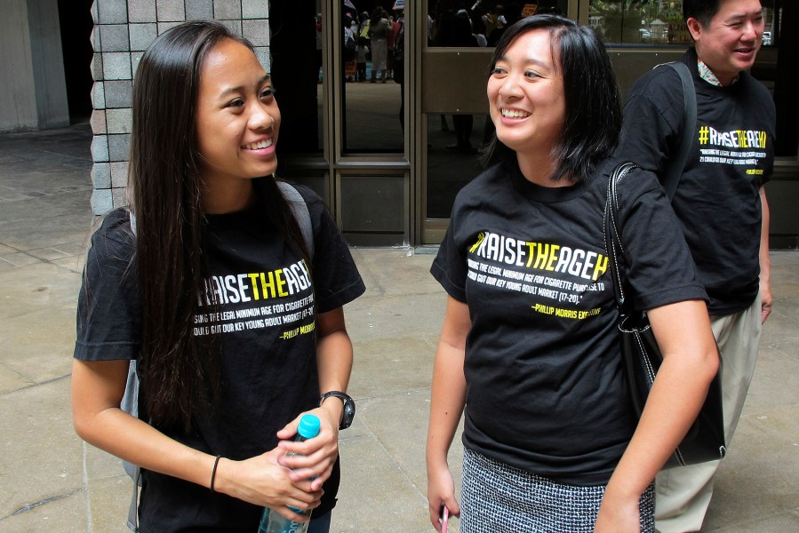 Two high school students who supports raising the legal smoking age talk outside the Hawaii Legislature after it passed a bill to raise the legal smoking age to 21 on Friday, April 24, 2015, in Honolulu. (Photo by Cathy Bussewitz/AP)