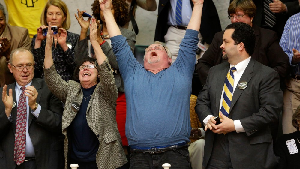 Anti-death penalty advocates Sylvester Schieber, left, his wife, Vicki, center, Kirk Bloodsworth, the first American sentenced to death row who was exonerated by DNA, and NAACP President Ben Jealous, right, react after watching the Maryland General...