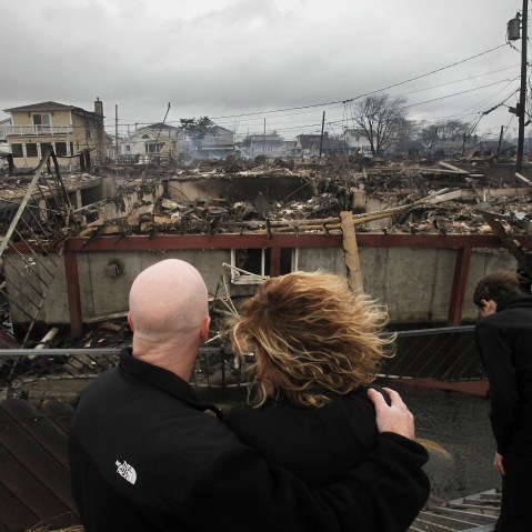 Robert Connolly, left, embraces his wife Laura as they survey the remains of the home owned by her parents that burned to the ground in the Breezy Point section of New York, Tuesday, Oct. 30, 2012. More than 50 homes were destroyed in the fire which...