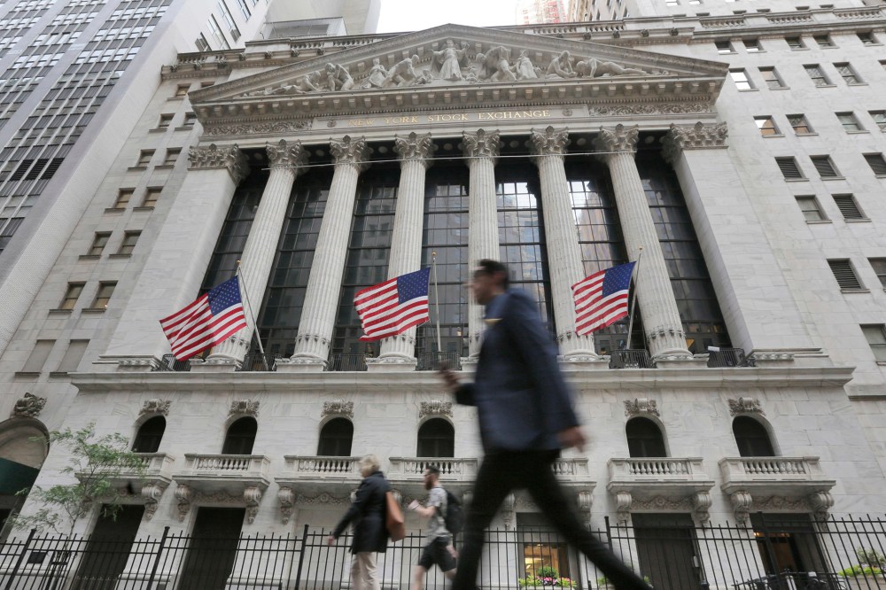 People pass the New York Stock Exchange, June 24, 2016 in New York, N.Y. (Photo by Richard Drew/AP)