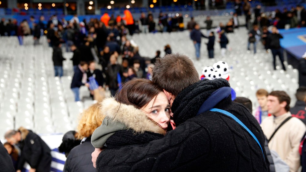 A supporter comforts a friend after invading the pitch of the Stade de France stadium at the end of the international friendly soccer match between France and Germany in Saint Denis, outside Paris, Nov. 13, 2015. (Photo by Christophe Ena/AP)