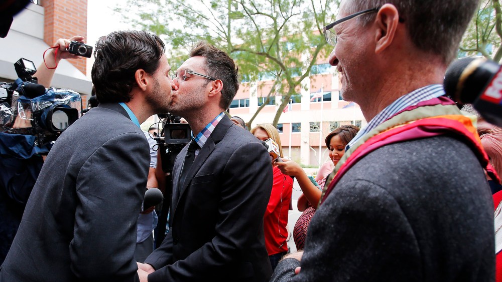 Kevin Patterson, left, and David Larance kiss after exchanging vows, as Rev. John Dorhaer, who performed the ceremony, stands at right, on Oct. 17, 2014, in Phoenix, Ariz.