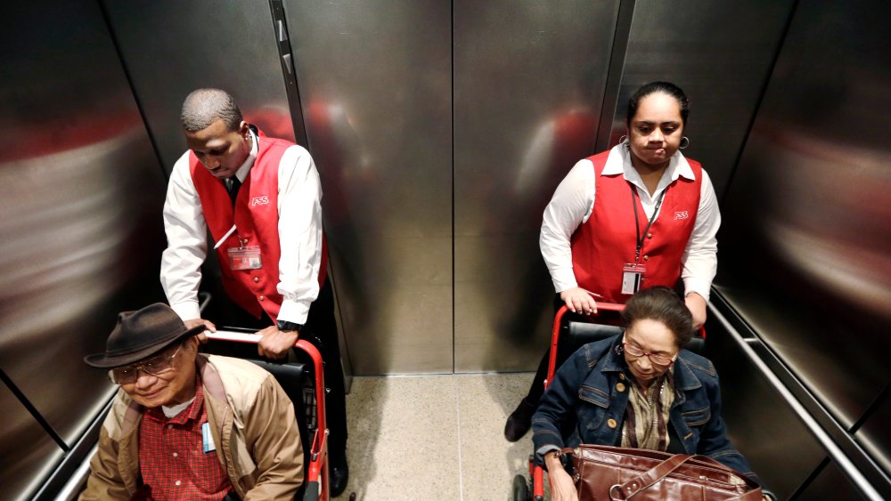 Erick Conley, left, and Sesilia Vaitele, wheelchair attendants at SeaTac airport, October 22, 2013, where voters are considering raising the minimum wage to $15/hour.