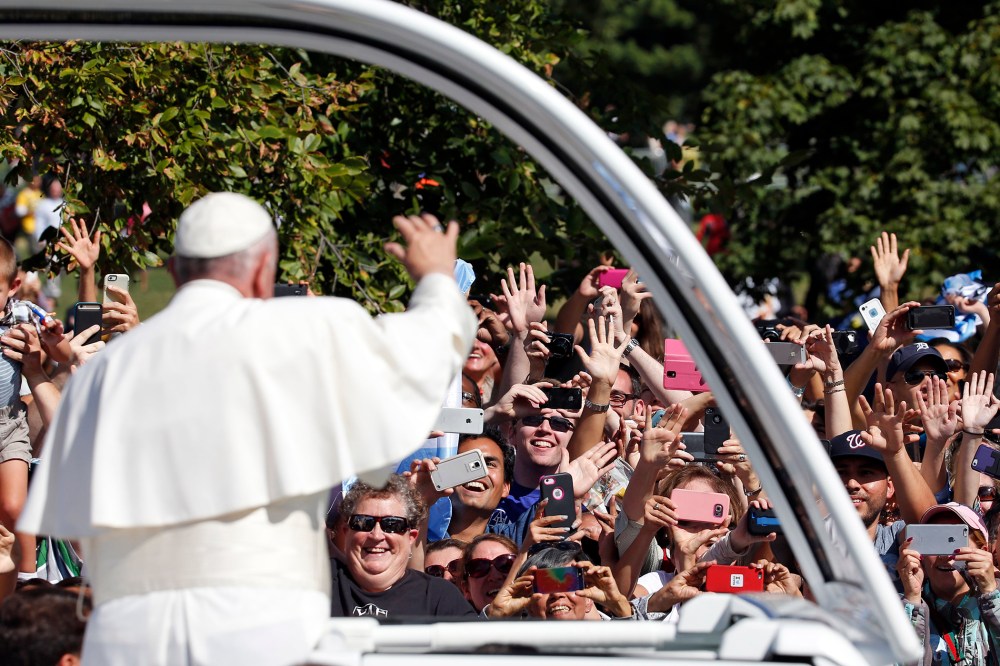 Pope Francis waves to the crowd from the popemobile during a parade in Washington, D.C., Sept. 23, 2015. (Photo by Alex Brandon/Pool/AP)