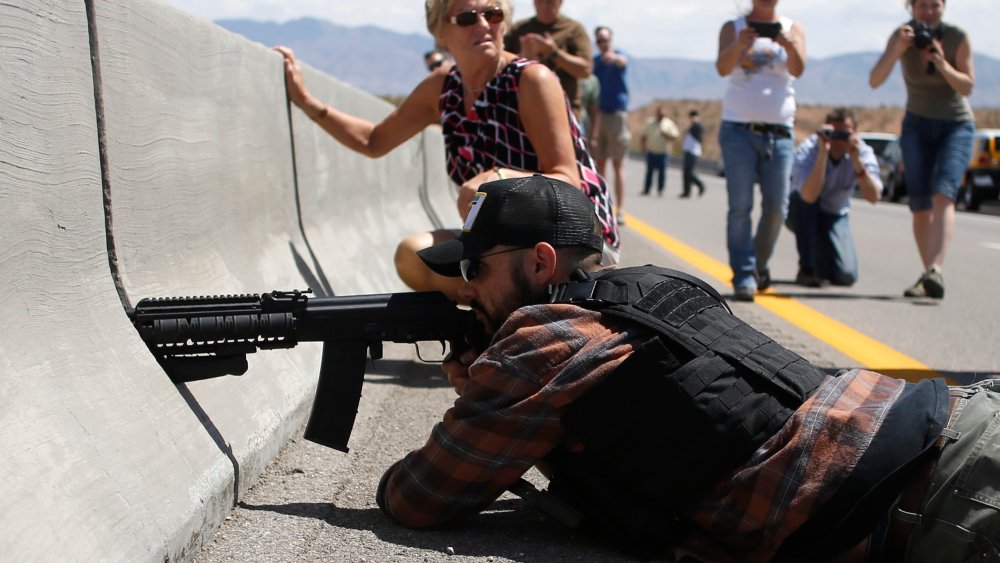 Protester Eric Parker aims his weapon next to the Bureau of Land Management's base camp where seized cattle are being held near Bunkerville, Nevada, April 12, 2014.