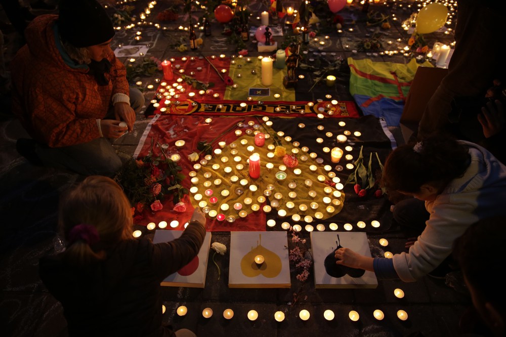 People light candles in tribute to victims at a makeshift memorial in front of the stock exchange at the Place de la Bourse (Beursplein) in Brussels on March 22, 2016. (Photo by Kenzo Tribouillard/AFP/Getty)