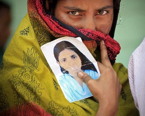 A woman holds a photo of her missing sister after a garment factory building collapsed last week in Savar near Dhaka, Bangladesh, Friday May 3, 2013. (AP Photo/Ismail Ferdous)