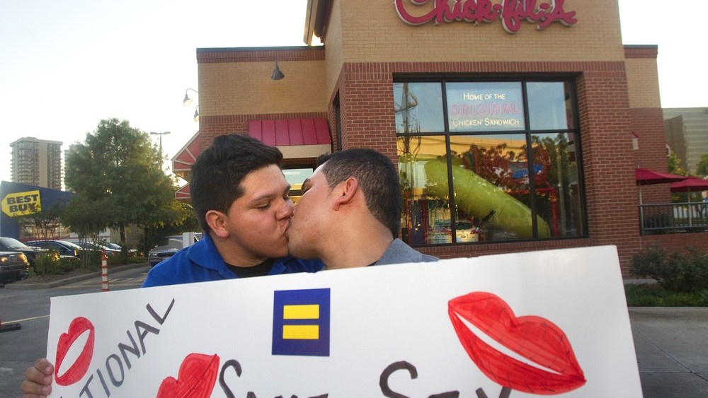 Miguel Martinez, left, kisses partner of five years, Sergio Andrade, right, during National Same Sex Kiss Day at Chick-fil-A in Houston on Aug. 3, 2012.