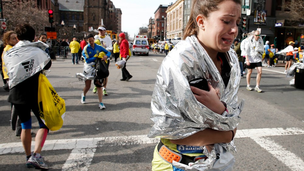 An unidentified Boston Marathon runner leaves the course crying near Copley Square following an explosion in Boston Monday, April 15, 2013. (AP Photo/Winslow Townson)
