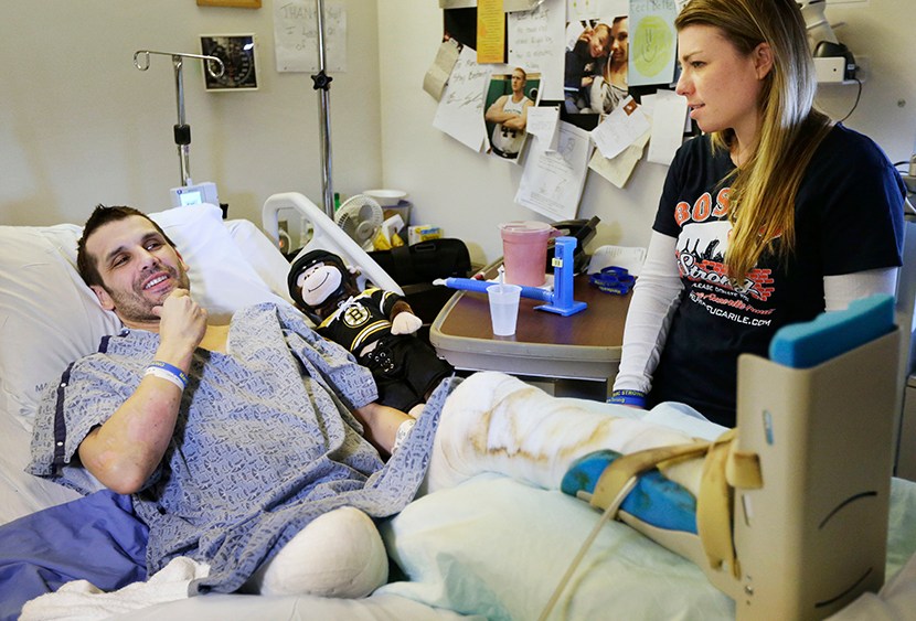 Marc Fucarile, left, speaks with members of the media as his fiancee, Jennifer Regan, right, looks on in his room at Massachusetts General Hospital in Boston on May 9, 2013.  (Photo by Steven Senne/AP)