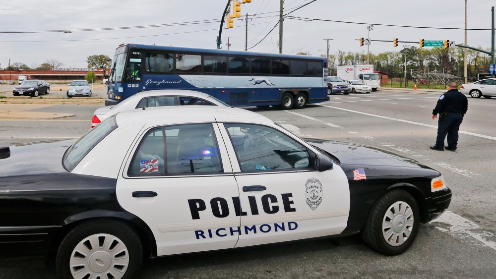 A Greyhound bus passes a police cruiser as it heads to the terminal, March 31, 2016, in Richmond, Va. (Photo by Steve Helber/AP)