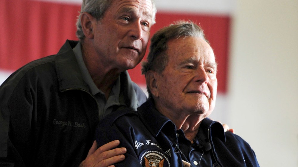 Former Presidents George W. Bush, (L) and George H.W. Bush deliver remarks to the crew during a ceremony aboard the aircraft carrier USS George H.W. Bush (CVN 77) during a promotion and reenlistment ceremony in the Atlantic Ocean in this handout photo...