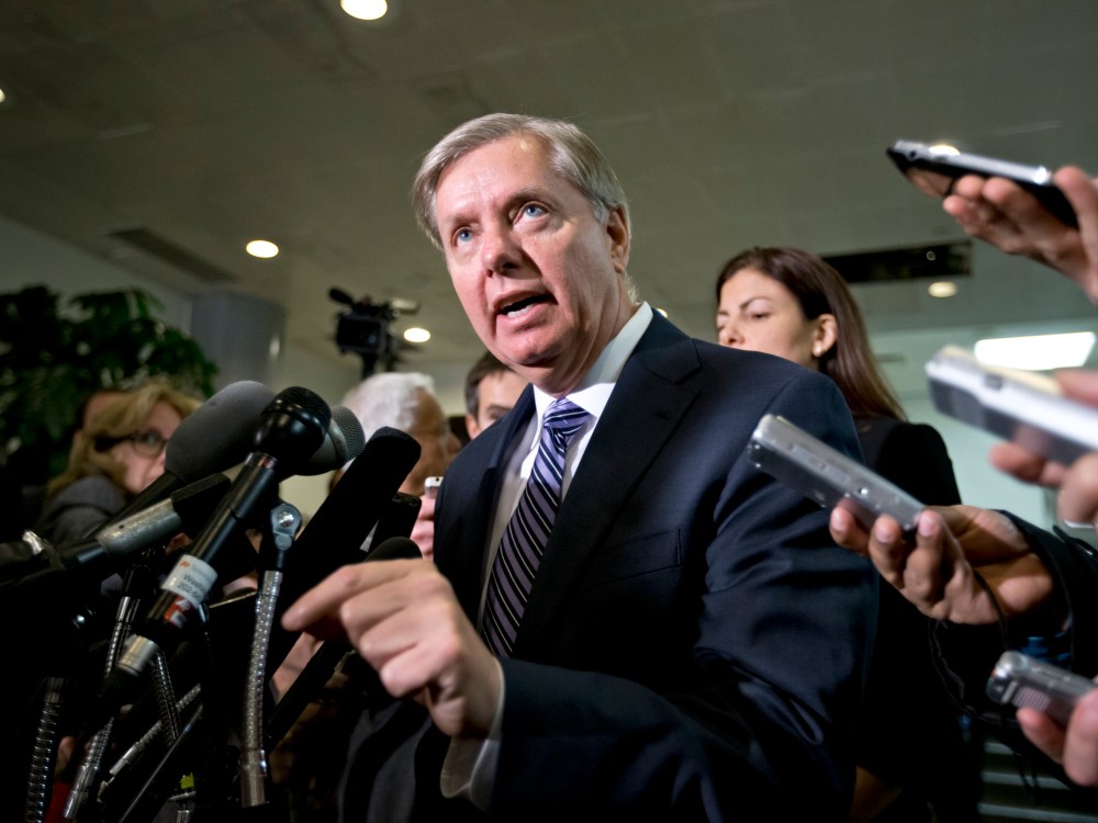 Sen. Lindsey Graham, R-S.C., a member of the Senate Armed Services Committee and the Senate Homeland Security Committee, center, accompanied by fellow Senate Armed Services Committee member, Sen. Kelly Ayotte, R-N.H.,, right, gestures while speaking to...