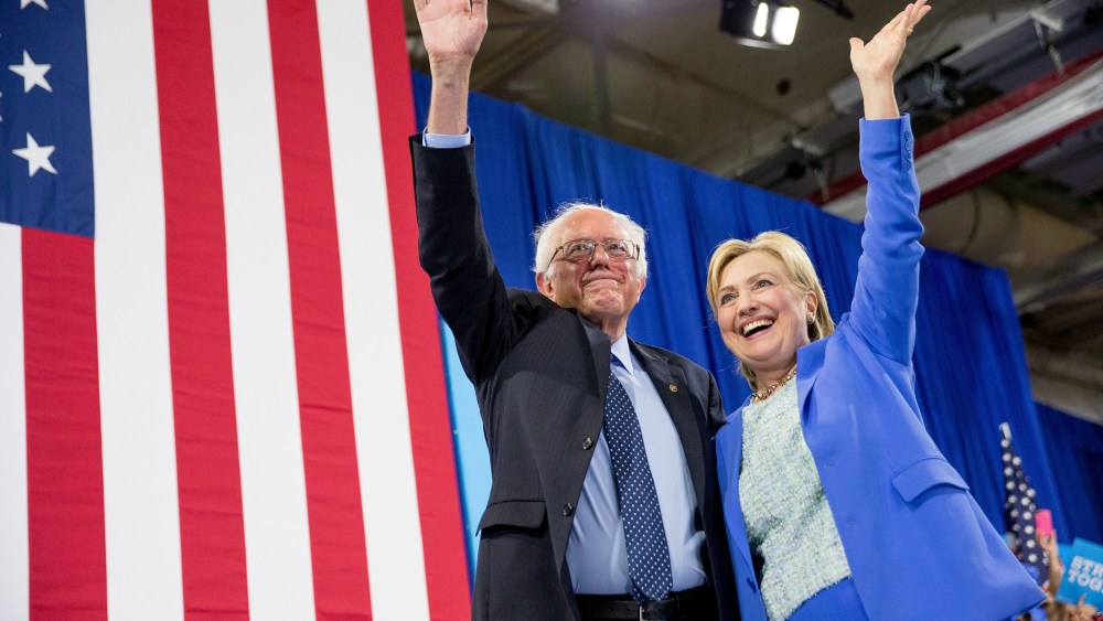 Democratic presidential candidate Hillary Clinton and Sen. Bernie Sanders, I-Vt., wave to supporters as Sanders endorsed Clinton during a rally in Portsmouth, N.H., July 12, 2016. (Photo by Andrew Harnik/AP)