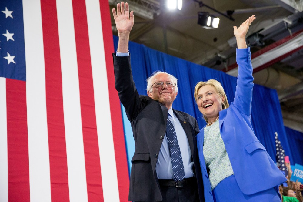 Democratic presidential candidate Hillary Clinton and Sen. Bernie Sanders, I-Vt., wave to supporters as Sanders endorsed Clinton during a rally in Portsmouth, N.H., July 12, 2016. (Photo by Andrew Harnik/AP)